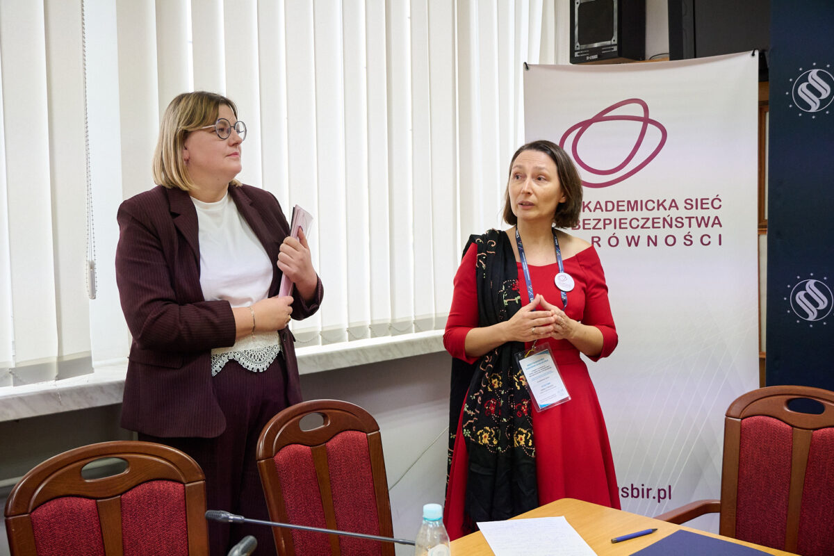 Przewodnicząca ASBiR Anan Cybulko i Joanna Zawisza stoją na tle roll up ASBiR