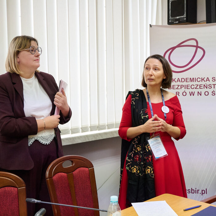 Przewodnicząca ASBiR Anan Cybulko i Joanna Zawisza stoją na tle roll up ASBiR